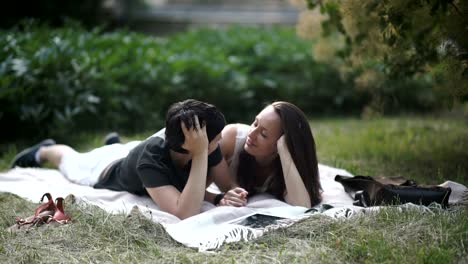 Dos-lesbianas-relajantes-sobre-el-verde-césped-en-el-Parque