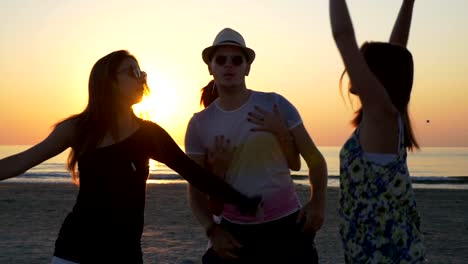 Friends-having-a-party-on-the-shore-of-the-sea-at-sunrise