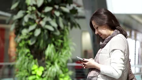 Mujer-usando-la-aplicación-smartphone-en-centro-comercial