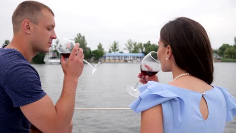 dos-personas-de-vacaciones,-gafas-en-mano-hombre-y-mujer-vista-desde-atrás,-descansan-sobre-el-agua,-hombre-y-mujer-bebiendo-vino