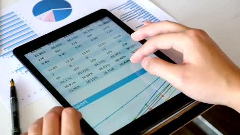 Financial-analysts-Meeting-charts-and-graphs-on-the-screen-of-the-touchpad