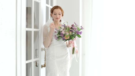 Bride-shyly-covers-her-face-with-a-veil.