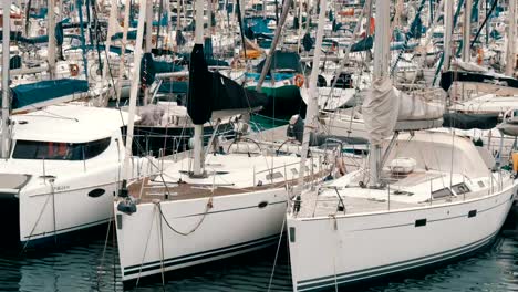 Lot-of-beautiful-white-stylish-yachts-moored-in-a-harbor-or-bay-in-Barcelona