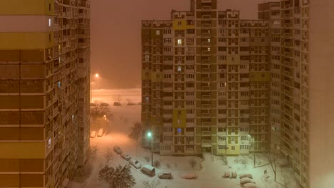 A-snowstorm-in-the-city.-View-from-the-window-to-the-courtyard-at-night.-down-up-timelapse