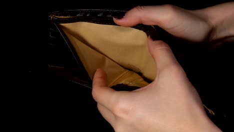 Female-hands-holding-empty-purse.-oung-woman-shows-her-empty-wallet.-Bankruptcy.