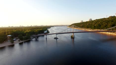 Herrlicher-Ausblick-auf-die-Stadt-von-oben.-Großstadt-mit-Brücke-über-Fluss-und-vielen-grünen-Bäumen.-Bedeckt.-Frühling.-Kiew