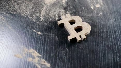 the-wooden-bitcoin-symbol-lies-on-a-dusty-table