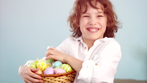 Cheerful-schoolboy-with-a-basket-of-Easter-eggs.-Curly-haired-boy-laughs-fun