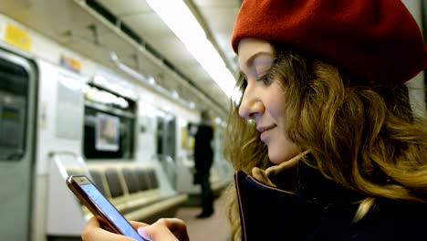 Schöne-junge-Frau-nutzt-eine-Smartphone-in-der-u-Bahn-Nahaufnahme,-eine-Mädchen-gibt-eine-Meldung-in-das-Telefon