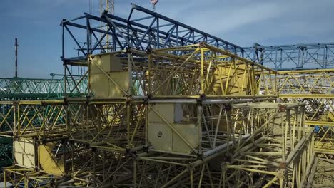 Perfiles-metálicos-de-la-grúa-de-construcción-desmantelaron-en-la-calle.-Equipo-de-construcción.-Construcciones-de-metal-amarillo.-Fondo-industrial