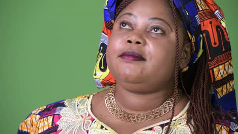 Overweight-beautiful-African-woman-wearing-traditional-clothing-against-green-background