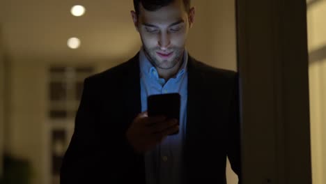 Business-man-using-mobile-alone-in-dark-office