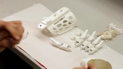 Close-up-of-male-enineer-assembling-artificial-hand-limb