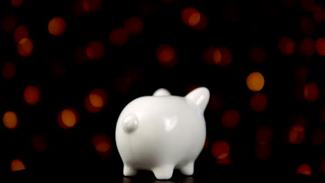 The-concept-of-charity-during-the-movember,-someone-puts-a-coin-in-piggy-bank.