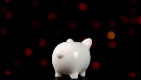 The-concept-of-charity-during-the-movember,-someone-puts-a-coin-in-piggy-bank.