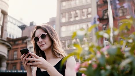 Happy-aufgeregt-kaukasischen-Bloggerin-in-Sonnenbrille-mit-Smartphone-app-Einkaufen-berühren-Haare-im-Sommer-New-York