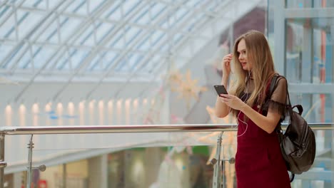 Smiling-female-blogger-listening-favorite-songs-in-headphones-while-posing-for-selfie-on-smartphone-camera,-hipster-girl-enjoying-radio-broadcast-making-photo-for-picture-in-social-networks-on-mobile