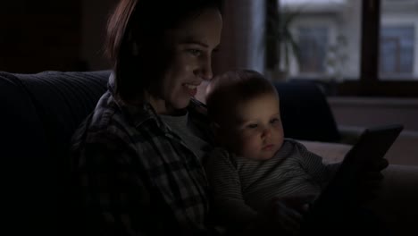 Mother-with-baby-girl-using-digital-tablet-at-night