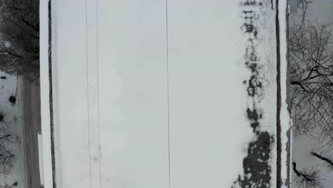 Fly-up-above-building-roof-covered-with-white-snow.