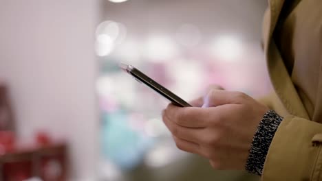 Female-hands-texting-on-smartphone-in-night-city