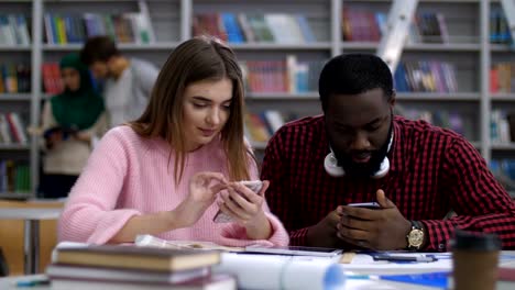 Diversos-estudiantes-de-compartir-contenido-en-línea-en-el-teléfono