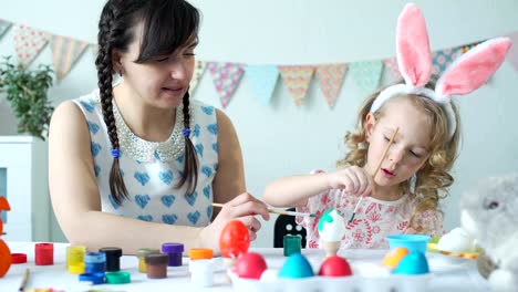 Little-Girl-Decorating-Easter-Eggs-with-Mother