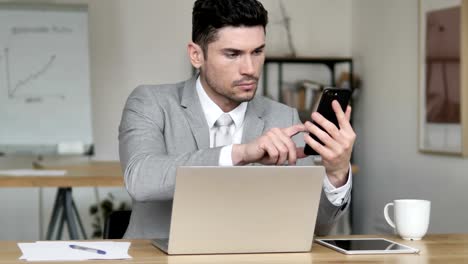 Businessman-Using-Smartphone-and-Laptop