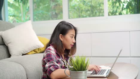 Young-business-freelance-Asian-woman-working-homework-on-laptop-on-the-desk-when-relax-in-living-room-at-house.-Lifestyle-latin-and-hispanic-ethnicity-women-working-at-home-concept.