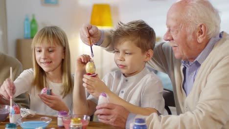 Familienschmelz-beim-Dekorieren-von-Ostereiern