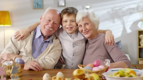 Porträt-von-Enkel-Hugging-Großeltern-und-Smiling