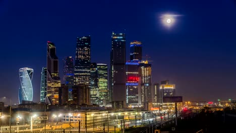 The-moon-rising-over-the-illuminated-highway-and-the-night-city,-time-lapse