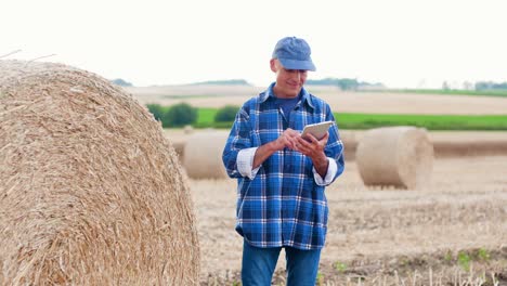 Agricultura-moderna.-Amor-a-la-agricultura.-Granjero-usando-la-tableta-digital-mientras-examina-la-granja