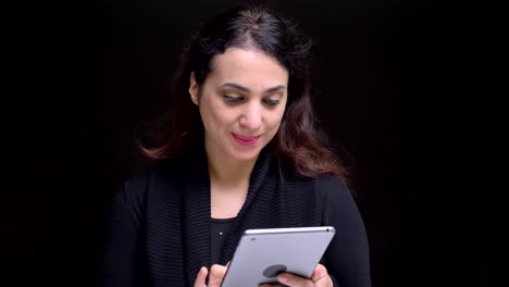 Retrato-en-primer-plano-de-joven-atractiva-mujer-caucásica-navegando-en-la-tableta-en-frente-de-la-cámara.