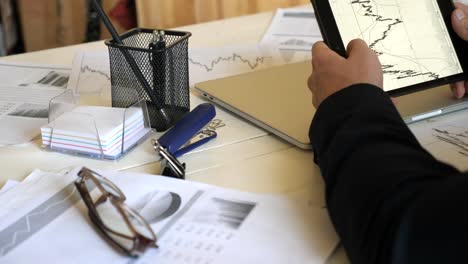 Male-hands-of-young-businessman-developing-a-business-project-and-analyzing-statistical-data-information-on-a-tablet-pc.-Successful-entrepreneur-working-on-modern-digital-device-in-office.-Close-up