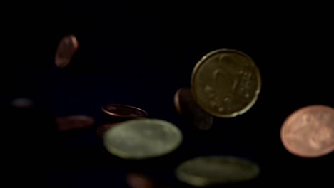 Coins-fall-on-a-black-background.-Slow-motion.