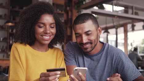 Pareja-en-un-café-de-compras-en-línea-con-tarjeta-de-crédito