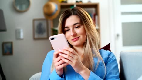 Porträt-von-Frauen-halten-Handy-rosa-Telefon,-Mädchen-SMS-mit-App-und-Video-auf-dem-Handy-zu-sehen,-genießen-das-Lesen-von-sozialen-Medien-zu-Hause