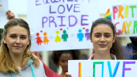 Pareja-femenina-defendiendo-los-derechos-de-las-minorías,-matrimonio-entre-personas-del-mismo-sexo,-marcha-de-orgullo