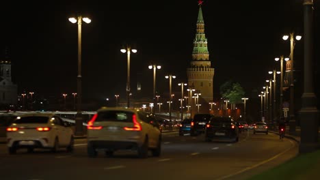 Moskau,-Russland.-10.-August-2019.-Nachtstadtbild,-die-Kremlmauer,-Autos-fahren-die-Straße-Kreml-Damm-hinunter