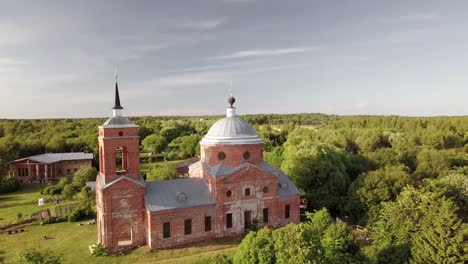 Aerial-view-of-the-Russian-forest,-river-and-steppe-overlooking-an-abandoned-Church-and-architectural-objects