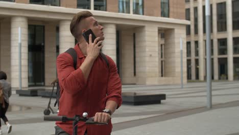 Man-Using-E-scooter-and-Having-Phone-Call