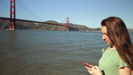 Woman-photographing-the-Golden-Gate-Bridge,-San-Francisco