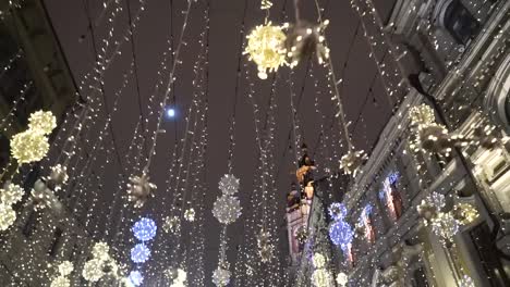 Defocused-view-of-pedestrians-walking-on-beautifully-decorated-for-winter-Christmas-Holidays-street-toward-the-biggest-European-Christmas-tree.-Moscow-Russia