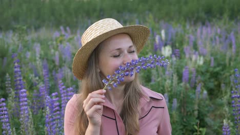 Frau-riecht-Lupinenblumen-verbringen-Zeit-auf-frischer-Wiese