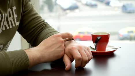 Man-using-smartwatch-at-coffee-shop-in-the-city