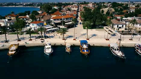 Aerial-travel-video-view-of-old-city-with-yacht-and-boats-at-marina-in-front-of-it.-Waterfront,-ocean-river-marina-port-dock,-boats-ships