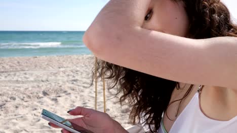 Comunicación-a-través-de-teléfono-móvil-en-vacaciones-de-verano,-chica-y-navegando-por-la-red-social-sobre-gadget,-joven-en-la-playa