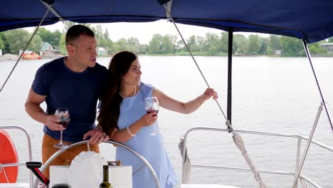 two-people-look-into-distance-on-resort,-happy-family-couple-drinking-wine-on-yacht,-rest-on-water,-romantic-couple-drink-red