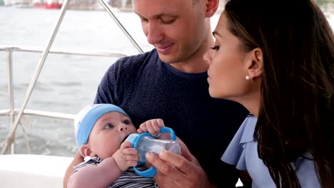 Familienleben,-feeds-Vater-Kind-Wasser-aus-Flasche,-Familie-mit-Baby-auf-Urlaub,-Eltern-und-Kind-mit-Flasche-am-Meer