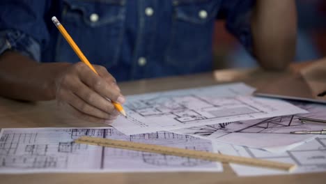 Student-architect-looking-at-apartment-layout-and-thinking-about-remodeling